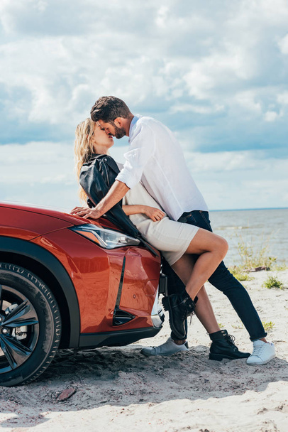 attractive woman and handsome man kissing on car outside  - Fotoğraf, Görsel