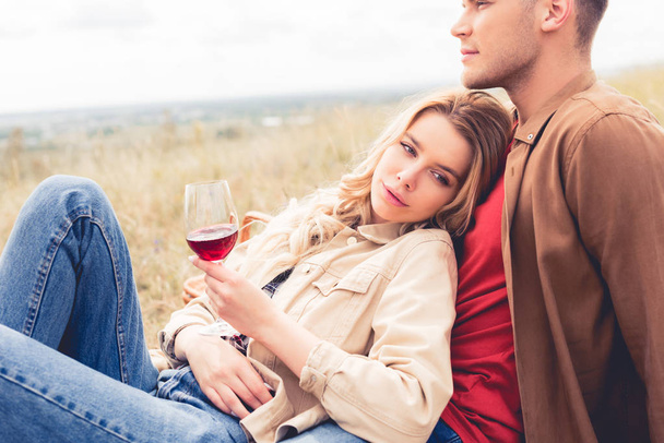 handsome man looking away and attractive woman holding wine glass - Φωτογραφία, εικόνα