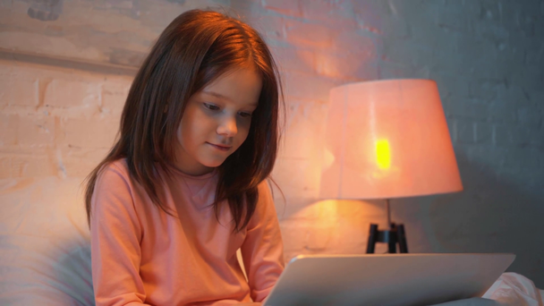 παιδί με φορητό υπολογιστή στο κρεβάτι τη νύχτα - Πλάνα, βίντεο