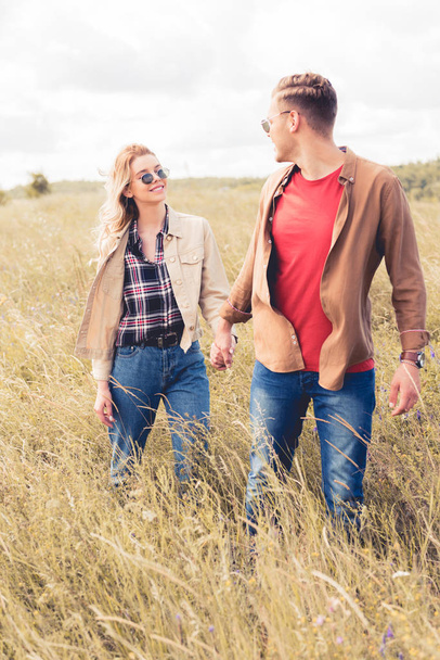 attractive woman and handsome man in sunglasses holding hands  - Valokuva, kuva