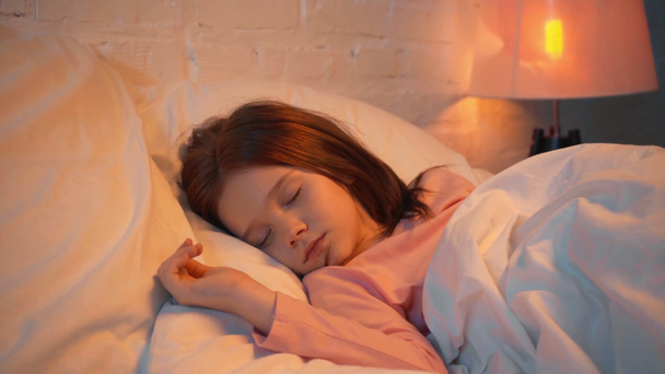 gyermek alszik fehér ágyban éjjel - Felvétel, videó