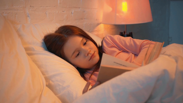 child reading book and falling asleep in bed at night - Footage, Video