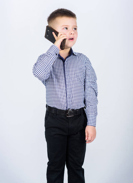 Mobile conversation. Mobile communication. Modern gadget. Small businessman. Business school. Upbringing and development. Little boy formal clothes call mobile phone. Cute boy hold smartphone - Фото, изображение