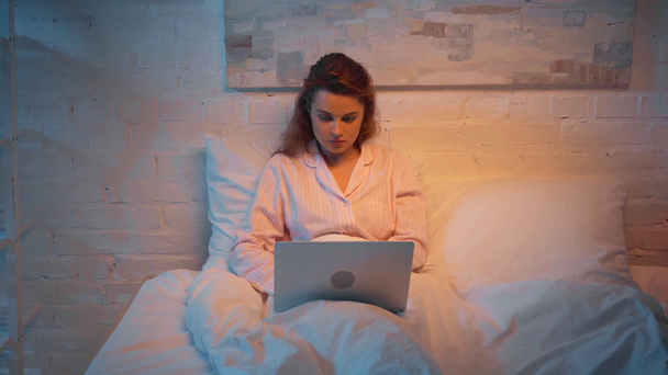gece yatakta dizüstü bilgisayar kullanan yetişkin kadın - Video, Çekim