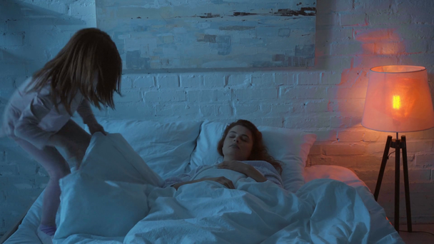 dorosły kobieta śpiące z córka w łóżko w noc - Materiał filmowy, wideo