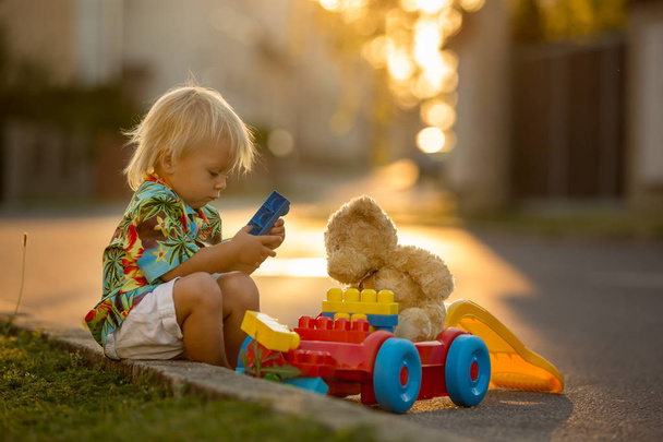 Beautiful toddler child, playing with plastic toys, blocks, cars - Foto, imagen