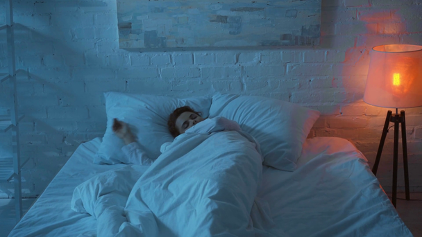 vrouw slapen in wit bed 's nachts - Video