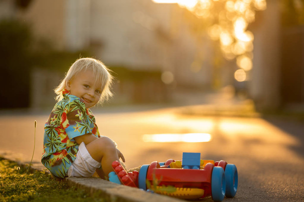 Beautiful toddler child, playing with plastic toys, blocks, cars - Foto, afbeelding