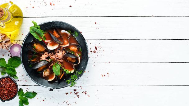 Tomato soup with seafood. Mussels, clams and octopuses. In the old background. Top view. Free copy space. - Φωτογραφία, εικόνα