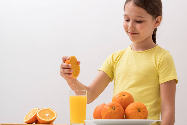 child squeezes orange juice with his hands	 - Foto, afbeelding