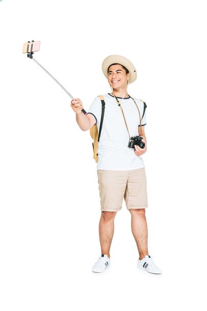 happy asian man taking selfie on smartphone with selfie stick on white background - Foto, Imagen