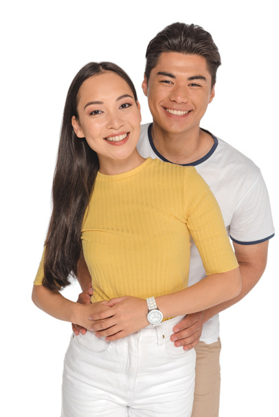 happy asian man embracing attractive girlfriend while smiling at camera isolated on white - Φωτογραφία, εικόνα