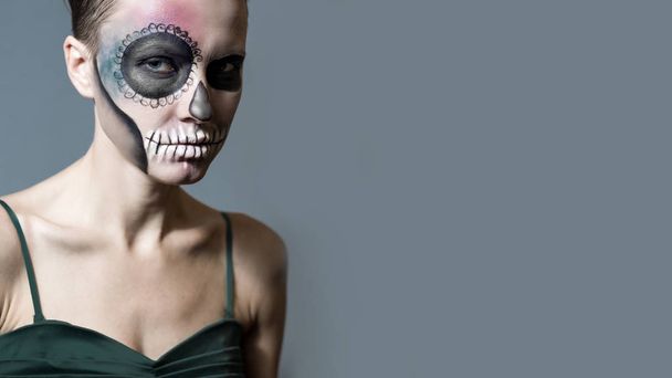 Halloween. Beautiful woman with bright black halloween makeup isolated over gray background - Фото, зображення