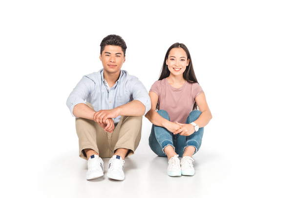 joven asiático hombre y mujer sentado en blanco fondo y sonriendo a la cámara
 - Foto, Imagen