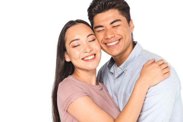 happy asian couple hugging with closed eyes isolated on white - Photo, image
