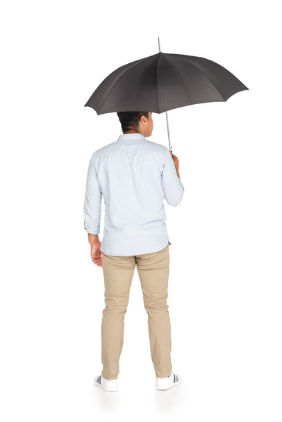 back view of young asian man standing under umbrella on white background - Foto, Imagem