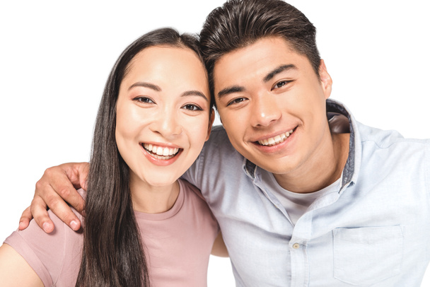 若くて幸せなアジアのカップルは、白に孤立したカメラで微笑む - 写真・画像