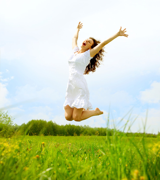 Happy Young Woman Jumping over blue sky. Beauty Girl Having Fun - Photo, Image