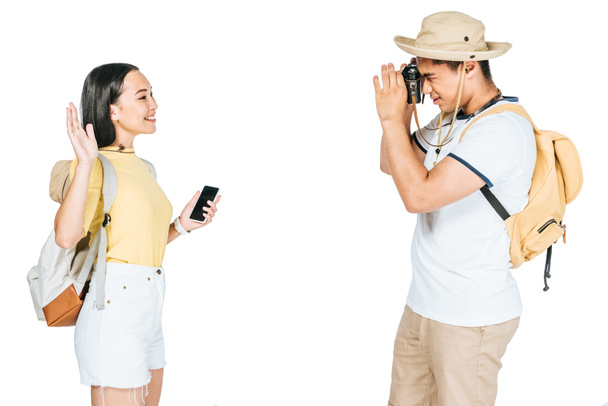 jeunes touristes asiatiques prenant la photo de petite amie agitant la main isolé sur blanc
 - Photo, image