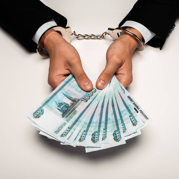 κομμένη θέα του επιχειρηματία σε χειροπέδες που κατέχουν Ρωσικά χρήματα σε λευκό  - Φωτογραφία, εικόνα