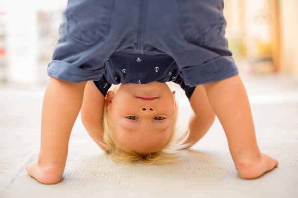 Child standing upside down, smiling happily - Photo, Image
