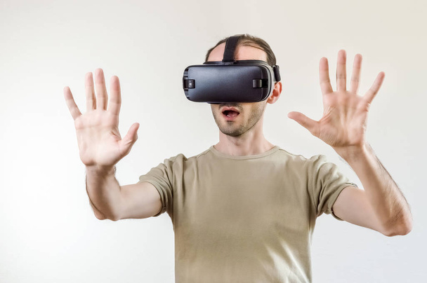 Hombre explorando la tecnología moderna realidad virtual con pantalla montada en la cabeza sobre fondo blanco
 - Foto, Imagen