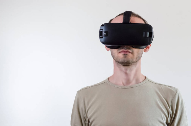 Homem explorando a realidade virtual de tecnologia moderna com exibição montada na cabeça no fundo branco
 - Foto, Imagem