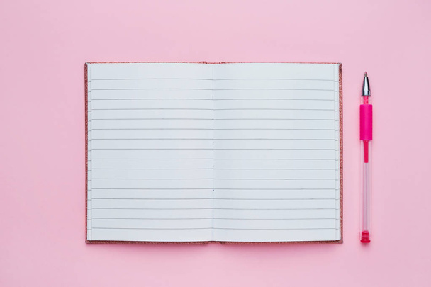 Vista superior de um caderno aberto com página em branco e caneta rosa. Voltar ao conceito de escola
.  - Foto, Imagem