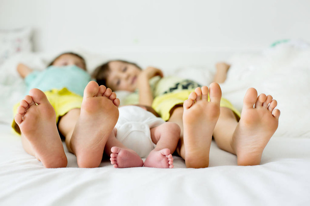 Pequeño niño pies, bebé se acuesta en la cama por la tarde
 - Foto, Imagen