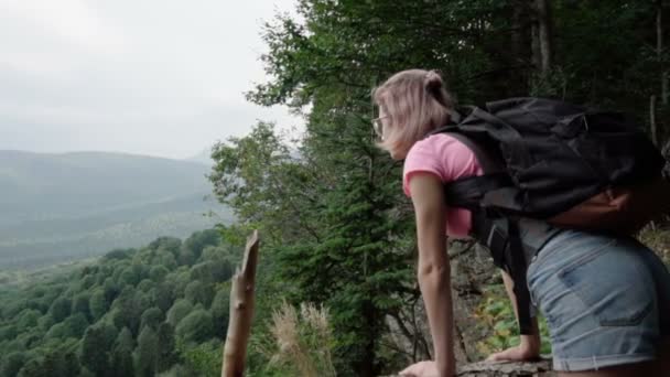 Dziewczyna patrzy na las z klifu - Materiał filmowy, wideo