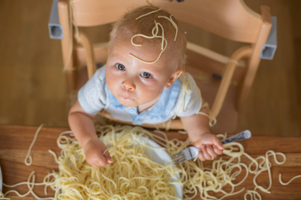 Little baby boy, toddler child, eating spaghetti for lunch and m - Фото, зображення
