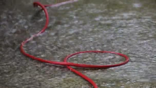 Punainen kaapeli rakennustyömaalla suuren sateen aikana
 - Materiaali, video