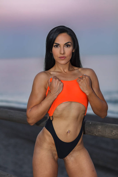 Fitness ragazza in posa con un bellissimo bikini nero e arancione
 - Foto, immagini