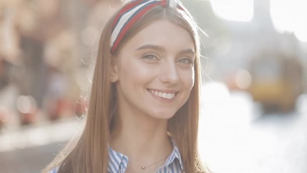 Close Up Portrait of Young Good Looking Girl with Brown Hair and Headband Wearing in Striped Dress Smiling and Holding Coffe Cup Looking to Camera Standing at the City Street Slow Motion. - 映像、動画