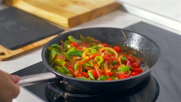 Der Koch rührt das Gemüse in der Pfanne um. Zeitlupe  - Filmmaterial, Video