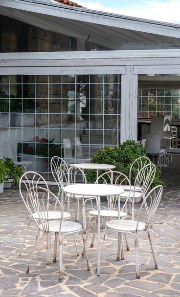 Καρέκλες και τραπέζια σε εστιατόριο κήπου στη Σαρδηνία - Φωτογραφία, εικόνα