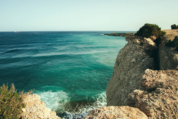 Cliffs near the sea, blue water. - Zdjęcie, obraz