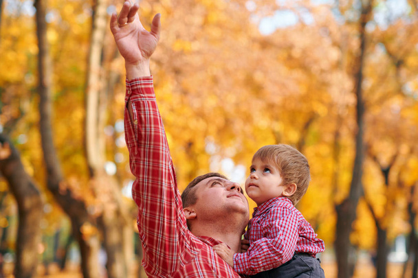Família feliz ter férias no parque da cidade de outono. Crianças e pais posando, sorrindo, brincando e se divertindo. Árvores e folhas amarelas brilhantes
 - Foto, Imagem