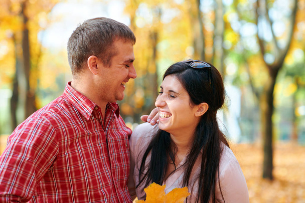Happy couple portrait in autumn city park. Bright yellow trees and leaves - Foto, Bild