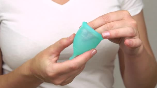womans hand uses lubricant to lubricate the menstrual cup intimate personal hygiene product for a comfortable installation during period time - Imágenes, Vídeo