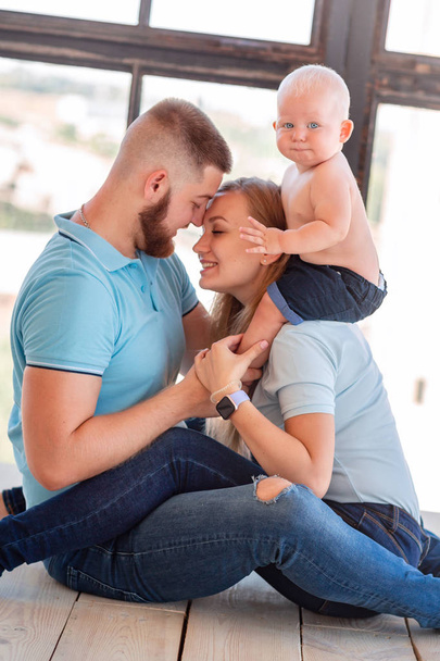 Young happy family with the baby indoors - Foto, Bild