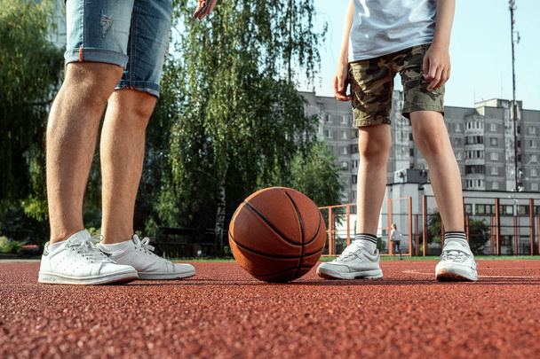 Father and son play basketball together at the basketball court. father spends time with the child, sporty lifestyle, training, rest, vacation. - Foto, immagini