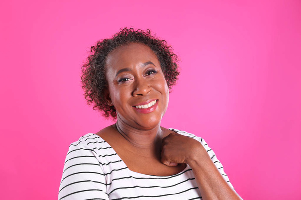 Portrait of happy African-American woman on pink background - Foto, afbeelding