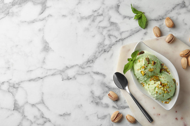Delicious pistachio ice cream on marble table, flat lay. Space for text - 写真・画像