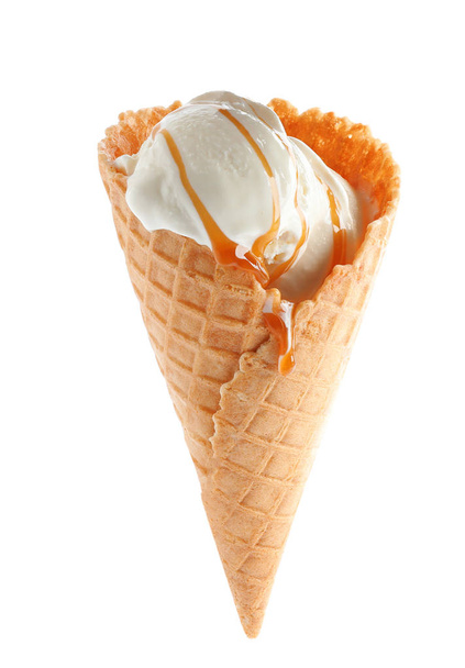 Delicious ice cream with caramel sauce in waffle cone on white background - Photo, Image