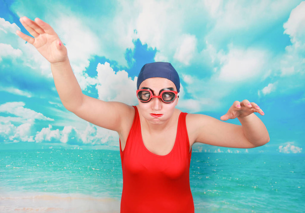 Crazy Diver in rode badpak met Zwembril op blauwe achtergrond. persoon zwemmer leren zwemmen. - Foto, afbeelding