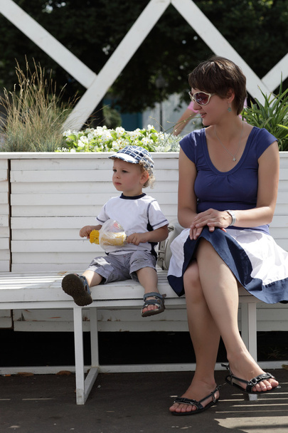Mother with toddler resting on bench - Zdjęcie, obraz