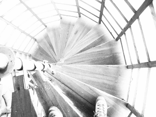 Escaliers circulaires dans la tour au sommet des montagnes Géantes, République tchèque avec des chaussures au début. Photo noir et blanc
. - Photo, image
