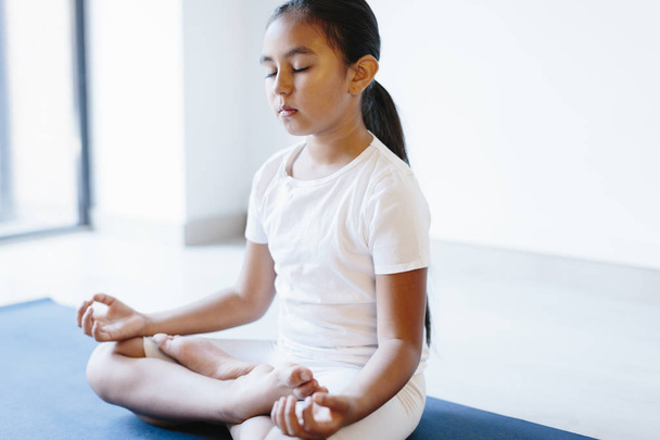 junges Mädchen macht Yoga auf weißem Hintergrund - Foto, Bild