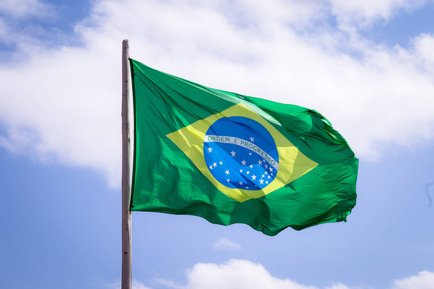 Drapeau national du Brésil tissu textile agitant sur le dessus, ciel bleu brésilien, concept de patriotisme
. - Photo, image